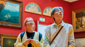 Young South East Asian couple with colourful hair basking in the art work at Leeds Gallery